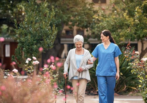 Shot of a caregiver and her patient out for a walk in the garden